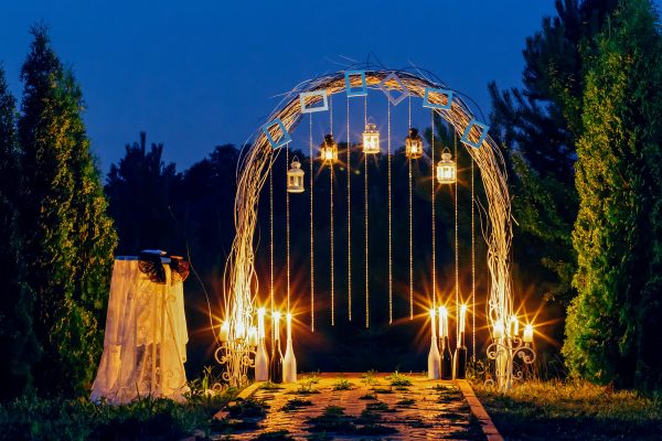 Wedding arch is beautiful at night with candles and lanterns